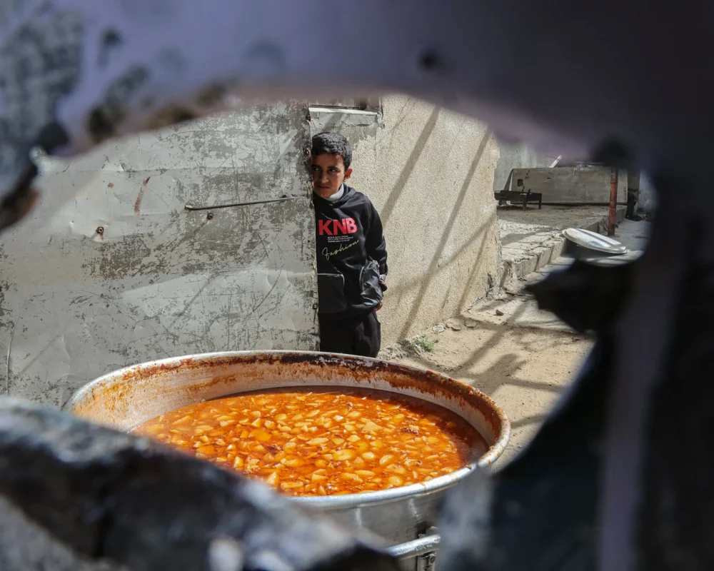 طفل فلسطيني ينتظر الحصول على وجبة إفطار مجانية خلال شهر رمضان في رفح جنوب قطاع غزة