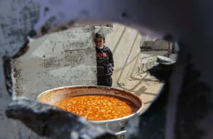 طفل فلسطيني ينتظر الحصول على وجبة إفطار مجانية خلال شهر رمضان في رفح جنوب قطاع غزة